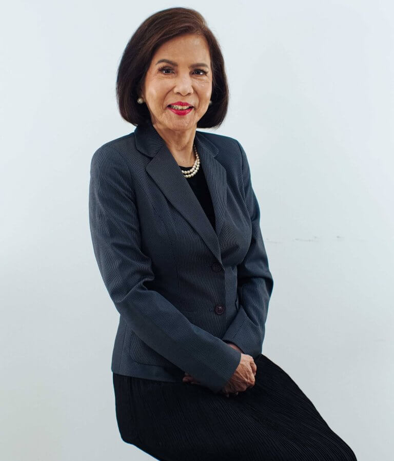 Professional portrait of a businesswoman with short hair wearing a tailored grey suit jacket.
