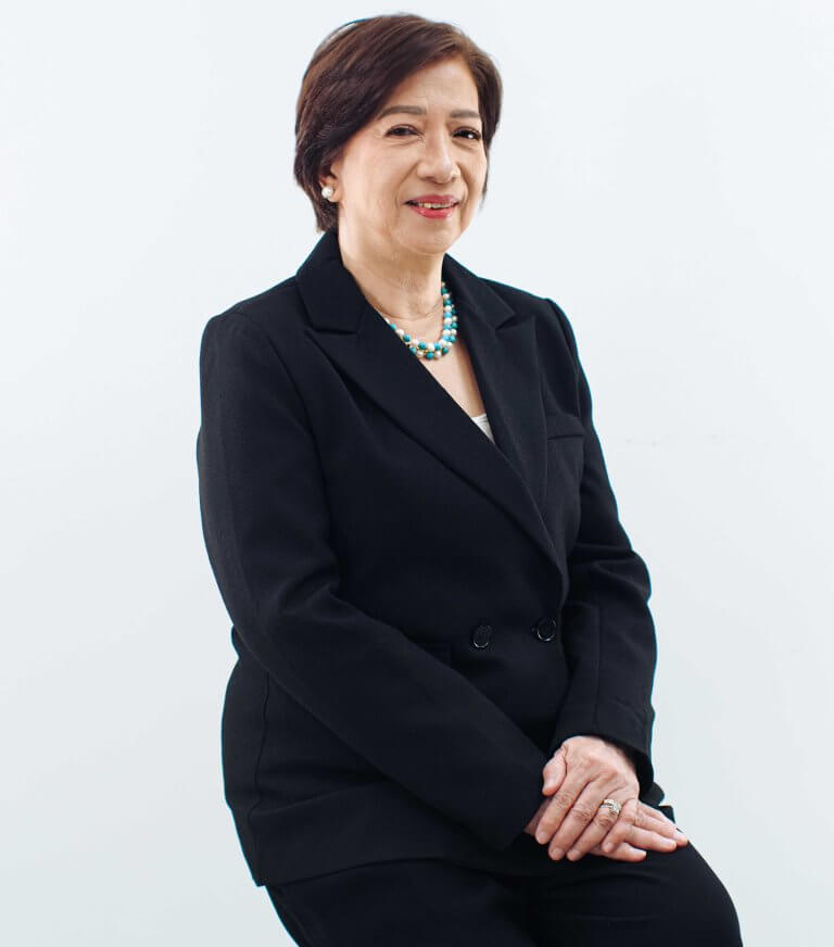 Professional corporate headshot of a woman in a black blazer posing with a polite smile.