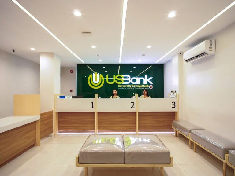 Well-lit interior of a modern University Savings Bank branch showing service counters and client seating area.